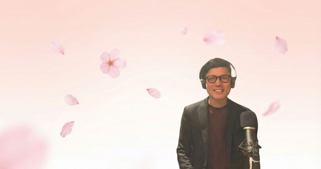 桜花ライフアカデミー代表・石井豊が笑顔で語る様子。背景には桜の花びらが舞っている。