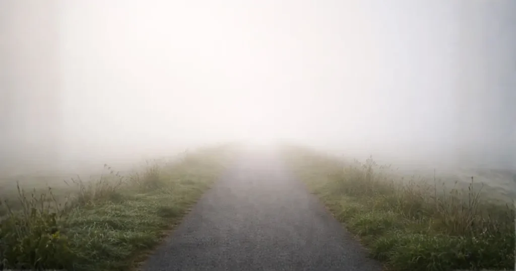 霧の中で先が見えない道を表現したイメージ