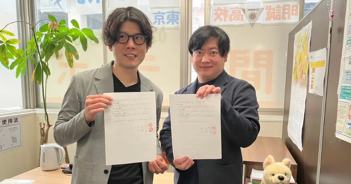 桜花ライフアカデミー代表・石井豊氏と滝野川高等学院校長・豊田毅氏が業務提携契約書を手に記念撮影